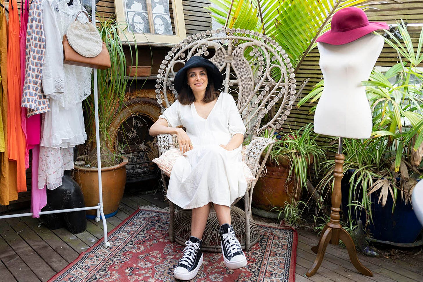 Tabitha Coleman of the Thrift Store sits on a chair surrounded by pre-loved goods.